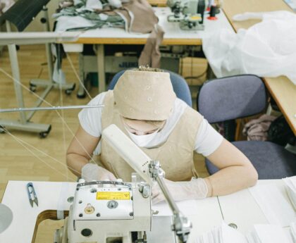 Women expertly sewing in a factory setting, focused on garment production using industrial machines.