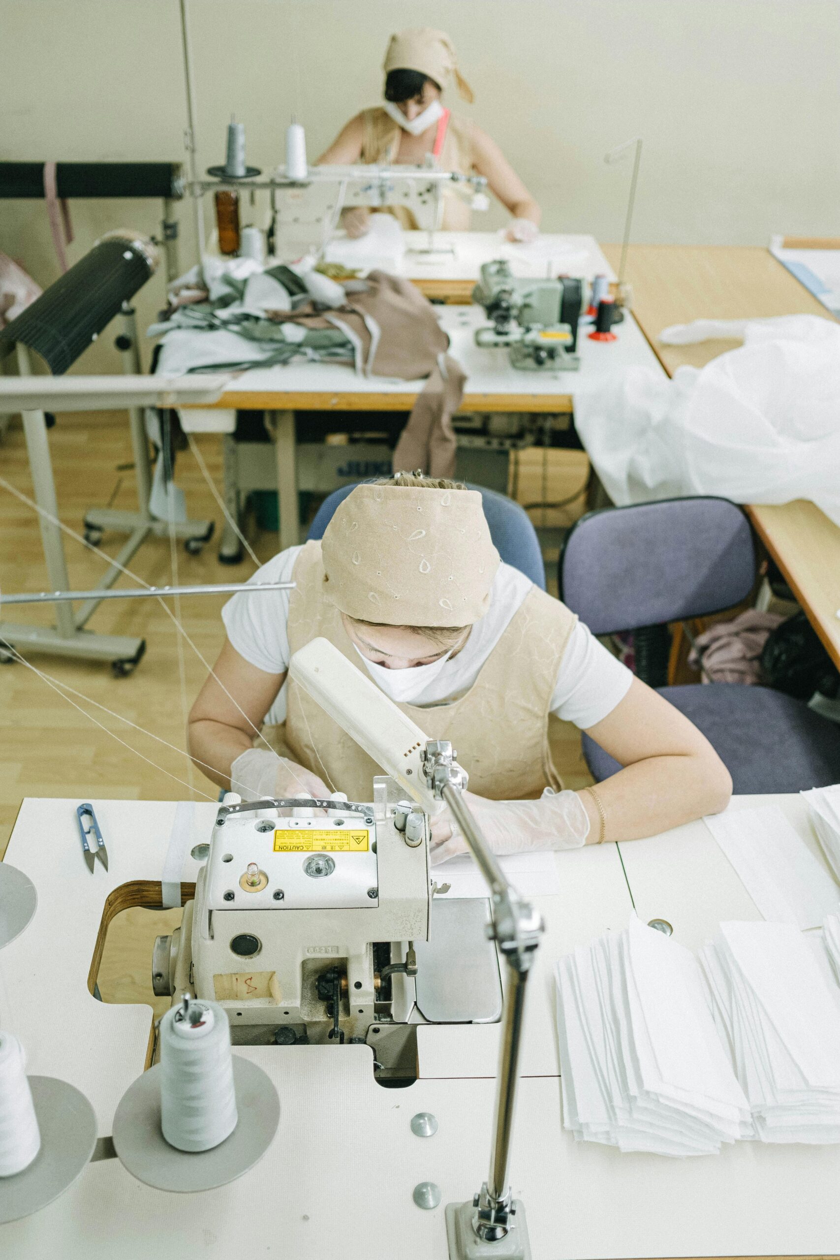 Women expertly sewing in a factory setting, focused on garment production using industrial machines.